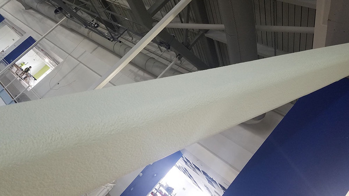 White pole in a facility with a fireproof coating. Commercial Fireproofing: Intumescent Paints vs Non-Intumescent Coatings