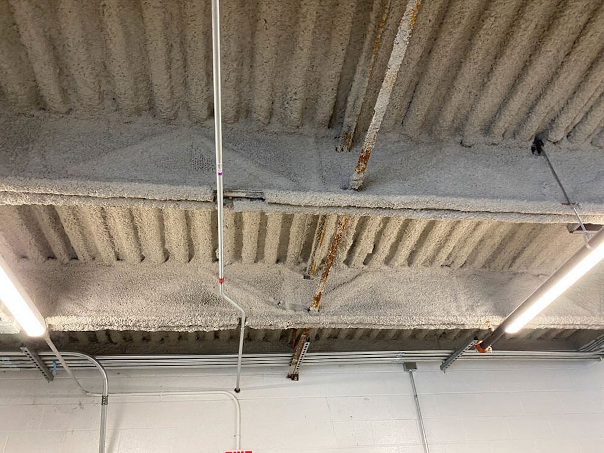 Cementitious fireproofing on a ceiling How Cementitious Fireproofing Saves Your Facility From Major Repairs
