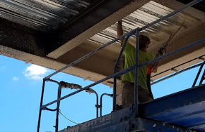 Worker applying fire retardant material on a ceiling. How to Choose the Best Fire Retardant Material for Your Commercial Building