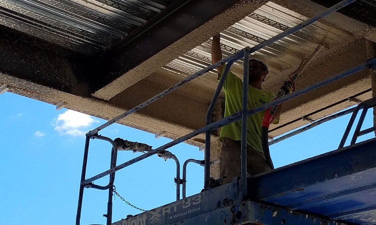 Worker applying fire retardant material on a ceiling. How to Choose the Best Fire Retardant Material for Your Commercial Building
