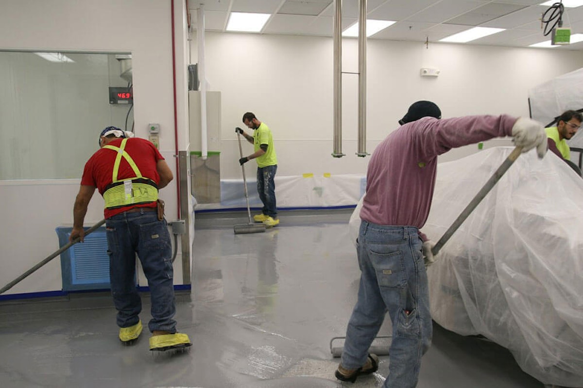 Employees cleaning concrete floor How to Remediate Old Concrete Flooring in Your Commercial Facility